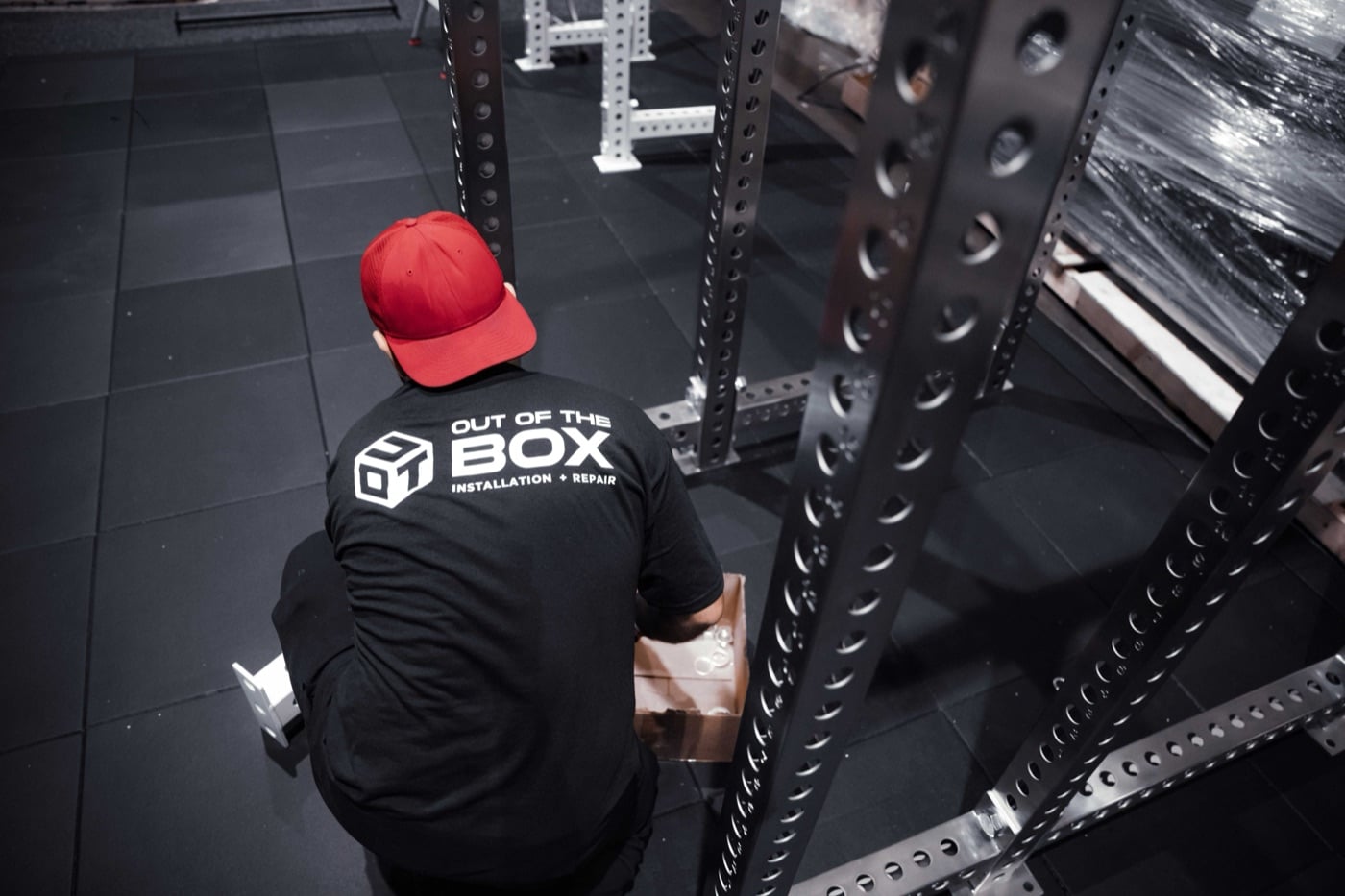 An Out of the Box technician assembling a power rack on-site
